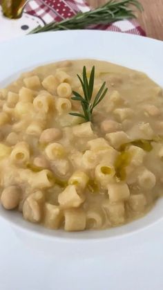 a white bowl filled with macaroni and cheese soup on top of a table