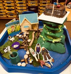 a blue tray filled with lots of toys and decorations on top of a wooden table