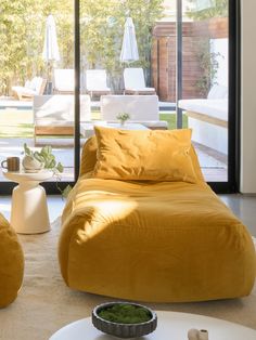 a living room filled with furniture and large windows