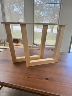 two wooden frames sitting on top of a table next to a window in a room