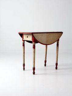 a small wooden table with two drawers on it's legs and an open drawer at the top