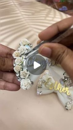 a person is cutting flowers with scissors on a white tablecloth that has the word love spelled in cursive letters