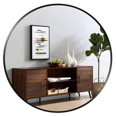 a wooden sideboard with two vases and a plant on it in front of a white wall