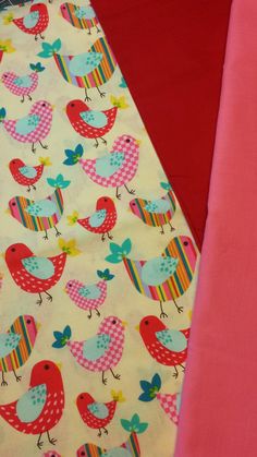 two colorful bedspreads with birds on them next to red sheets and pink sheets