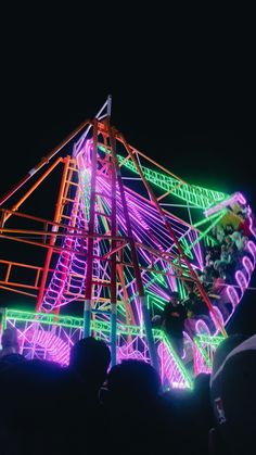 a carnival ride lit up at night with neon lights