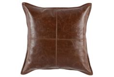 a brown leather pillow on a white background