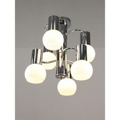 a chrome chandelier with five lights and four shades of white balls on it