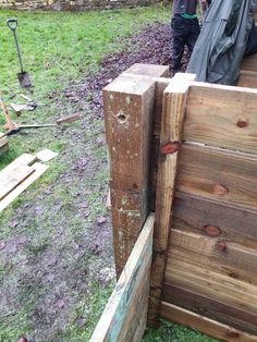 two men working on a wooden fence in the yard