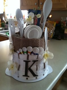 a cake with spoons, forks and utensils in it on a kitchen counter