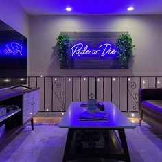 a living room filled with furniture and purple lighting on the wall above it is a sign that reads ride or die