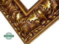 an ornate gold letter v with animals on it's sides and the word vermont written in green