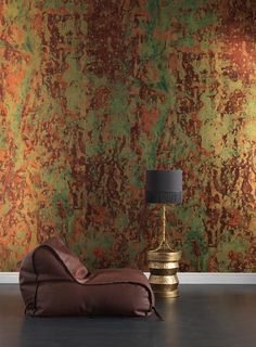 a chair and lamp in front of a wall with rusted paint