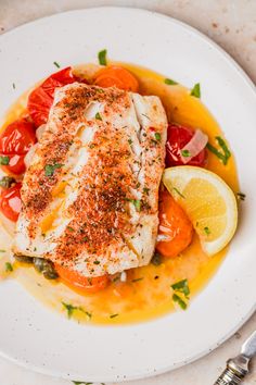 a white plate topped with fish and vegetables