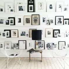 a living room with white walls and pictures on the wall