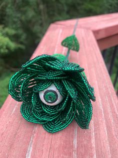 a close up of a green flower on a wooden surface