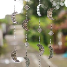 a wind chime hanging in front of a window with the moon and stars on it