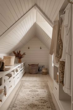 an attic bedroom with white walls and wooden flooring, built in shelving units