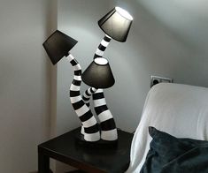 two black and white striped lamps on a night stand