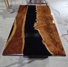 a table made out of wood and glass with a black stripe on the top that has been cut in half