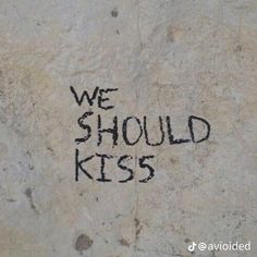 graffiti written on the side of a wall that says, we should kiss