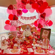 a valentine's day dessert table with red and pink balloons, heart shaped decorations, and cards