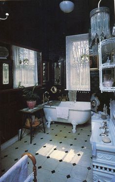 an old fashioned bathtub and sink in a bathroom with white tile flooring, black walls and ceiling