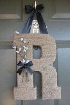 a door hanger with the letter b and flowers on it's front porch