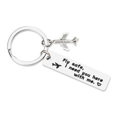 a keychain with an airplane and the words fly safe, i need you here with me