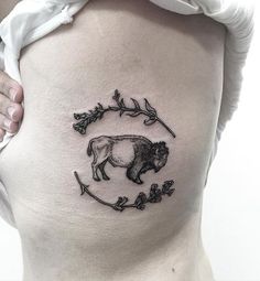 a bison tattoo on the side of a woman's lower back ribcage