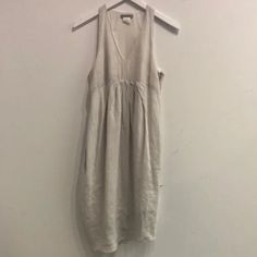 This Sleeveless Midi Dress From Sarah Pacini Is Made In An Off-White Linen, And Features A V-Shaped Neckline, A Pleated Empire Waist, A Racer Back, Side Seam Pockets, An Asymmetrical Hem, An Invisible Side Zip Closure, And Is Lined In A White Cotton. Condition: Very Good; Some Marking, Light Snagging Size: 1 (S) Approximate Measurements: Shoulder: 9" (23 Cm) Chest: 17.5" (44.5 Cm) Length From Back: 36" (91.5 Cm) Composition: Shell: 100% Linen. Lining: 100% Cotton. Sarah Pacini, Sleeveless Midi Dress, Midi Dress Sleeveless, Asymmetrical Hem, Racer Back, Asymmetric Hem, White Linen, Empire Waist, V Shape