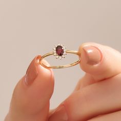 Elevate your love story with our 14k Solid Gold Minimalist Garnet Oval Ring, a symbol of elegance and timeless commitment. This flower engagement ring for women features a small red gemstone halo, adding a touch of romance to your style. Crafted in real gold, it's not just a piece of jewelry; it's a symbol of your unique love and sophistication, making it perfect for your special moment.    Ring Details  ❥ 14k Solid Gold(also in 10, 18K)  ❥ Gold Color Options; Yellow Gold, White Gold, Rose Gold Garnet Engagement Ring Gold, Red Garnet Jewelry, Gold Garnet Ring, Flower Engagement, January Birthstone Jewelry, January Birthstone Rings, Garnet Engagement Ring, Red Stone Ring, Flower Engagement Ring