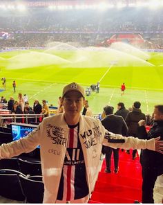 a man standing in front of a water sprinkler at a soccer game