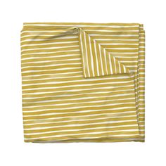 two yellow and white striped sheets on top of each other, one folded up to show the