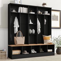 a black bookcase filled with lots of books next to a vase and potted plant