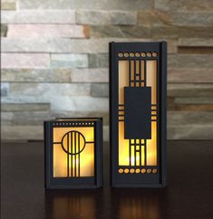 two lit candles sitting on top of a table next to each other, one in the shape of a door