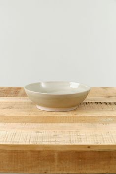 a white bowl sitting on top of a wooden table