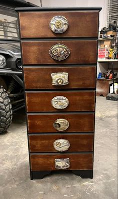 a wooden dresser with metal knobs on it's drawers in a garage next to a truck