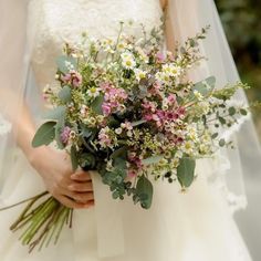 a bride holding a bouquet of flowers in her hands