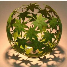 a glass ball with green leaves on it