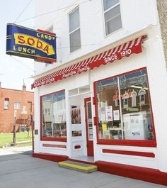 a storefront with red and white awnings on the side of it's building