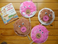 three paper plates with pigs on them sitting on a wooden floor next to a book