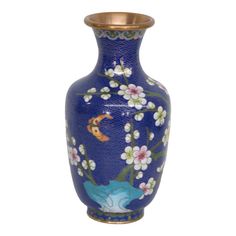 a blue vase with white flowers and gold trimmings on the bottom is shown in front of a white background