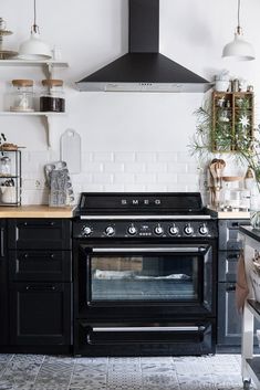 a black stove top oven sitting inside of a kitchen next to a wall mounted range