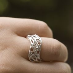 Two undulating curves define the form of this sterling silver ring which was cast from a 3d printed wax. Two layers of pattern create spatial depth and a sense of movement. Twisted ellipses march around the outer surface, while the interior one is formed by more circular cells. The ring is a part of our Cell Cycle line, created through simulations of spring meshes. Using our own software, we sculpted each design, transforming a simple mesh to a complex patterned structure. Please leave a comment with your order specifying which size you would like. item no 41 Lost Wax Casting Rings, 3d Printed Ring, Wax Carving Jewelry, 3d Tiskárna, Architectural Rings, Cast Rings, Wave Jewelry, Cell Cycle, Wax Ring