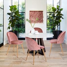 a dining room with pink chairs and a white table