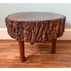 a tree stump table with wooden legs on the floor