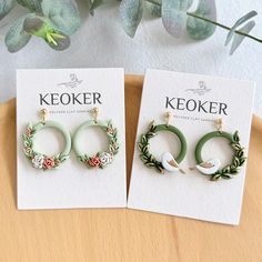 two pairs of keoker earrings sitting on top of a table