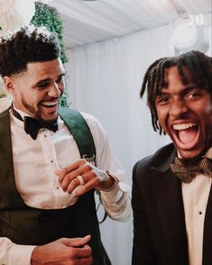 two men in tuxedos are laughing together