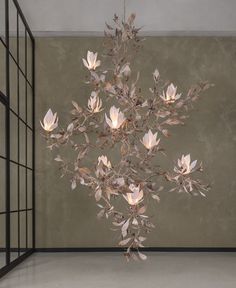 a chandelier with white flowers hanging from it's sides in a room