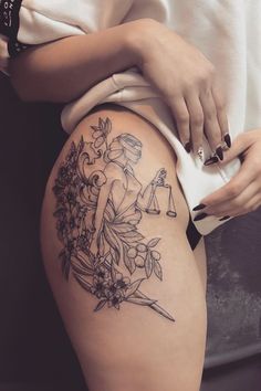 a woman's thigh with flowers and an hourglass tattoo on her left side